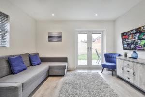 sala de estar con sofá y silla azul en Magnificent, Renovated Whole House with Parking by Ark SA en Sheffield