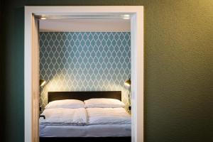 穆尔滕ADLER Boutique Hotel的一间卧室配有一张大床和床头板