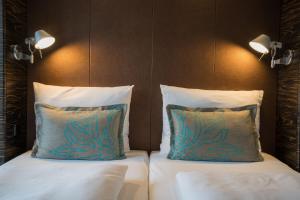 a bed with two pillows on top of it at Motel One Leipzig-Augustusplatz in Leipzig