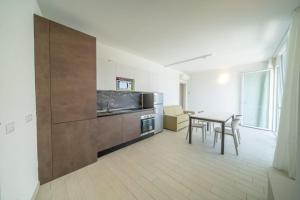 a living room with a table and a kitchen at Sabbia & Mare in Rosolina Mare
