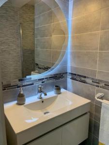 uma casa de banho com um lavatório e um espelho em Chez Mado em Deauville