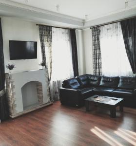 コヴロフにあるPalazzo Kovrovのリビングルーム(黒い革張りのソファ、暖炉付)