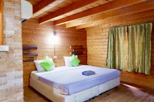 a bedroom with a bed in a wooden cabin at Samed sand sea resort in Ko Samed