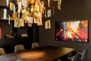 a room with a table and a tv and a fireplace at Motel One Leipzig-Post in Leipzig