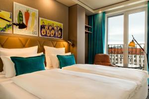 a hotel room with a large bed and a window at Motel One Leipzig-Post in Leipzig