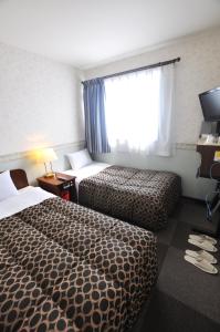 Кровать или кровати в номере Futsukaichi Green Hotel