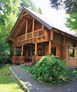 a log cabin with a porch and a balcony at Chalet mit Schlossblick Wernigerode, Chalet 2 in Wernigerode