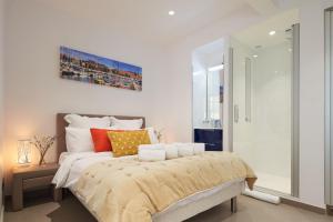 1 dormitorio con 1 cama grande con almohadas de color naranja y amarillo en Sunlight Properties - Sky blue - 3 bedroom flat with sea view on the Promenade des Anglais, en Niza