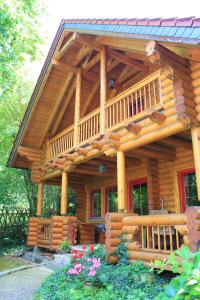 a large wooden cabin with a large deck at Chalet mit Schlossblick Wernigerode, Chalet 2 in Wernigerode
