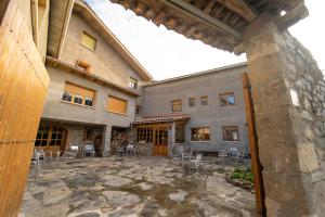 un edificio con un patio con mesas y sillas en HOSTAL RURAL CAL XIC Saldes, en Saldes