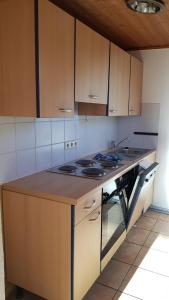 Una cocina con gabinetes de madera y un horno de estufa. en Wanderoase, en Melsbach