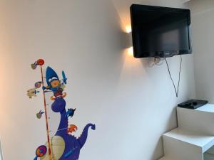 um quarto com uma televisão com um autocolante de rato Mickey na parede em Casino Beach em Koksijde