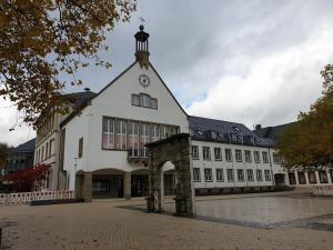 un grand bâtiment blanc avec une tour d'horloge. dans l'établissement Ferienwohnung Wicker, à Attendorn