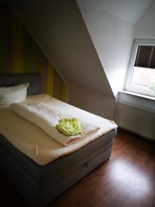 a bed sitting in a room with a window at Pension Kuehnauer Hof in Dessau