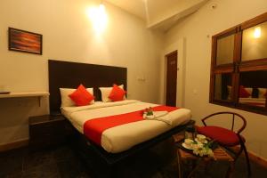 um quarto de hotel com uma cama com almofadas vermelhas em Le Apex em Auroville