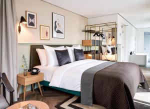 - une chambre dotée d'un grand lit avec des draps et des oreillers blancs dans l'établissement Park Centraal Den Haag, part of Sircle Collection, à La Haye