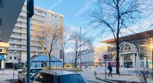 une rue avec une voiture garée devant un bâtiment dans l'établissement Chez edGARE à Chambéry, à Chambéry