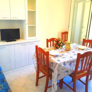 eine Küche mit einem Tisch mit Stühlen, einem Tisch und einem Tisch in der Unterkunft Case Vacanza IonianTravel Gallipoli in Gallipoli