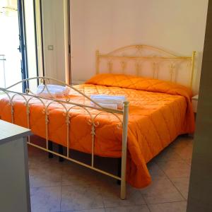 ガリポリにあるCase Vacanza IonianTravel Gallipoliのベッド1台(オレンジ色の掛け布団付)