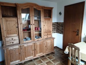 d'un meuble en bois avec des portes en verre dans la cuisine. dans l'établissement Ferienwohnung Wicker, à Attendorn