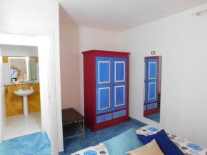 Cette chambre dispose d'une porte rouge et bleue et d'un lavabo. dans l'établissement Case Vacanza Elisir, à Favignana