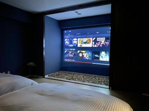 TV de pantalla grande en un dormitorio con cama en Parkside Inn Hakata No4, en Fukuoka