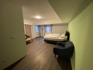 ein Schlafzimmer mit einem Bett und einem Stuhl in einem Zimmer in der Unterkunft JG Hotel Memmingen in Memmingen