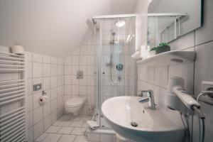 ein Badezimmer mit Waschbecken, Dusche und Toilette in der Unterkunft Airport Lounge Hotel Düsseldorf in Düsseldorf