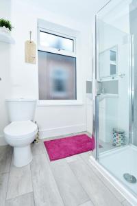 a bathroom with a toilet and a glass shower at Townhouse @ 543 London Road Stoke in Trent Vale