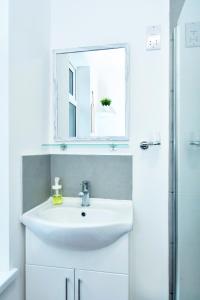 bagno con lavandino bianco e specchio di Townhouse @ 543 London Road Stoke a Trent Vale