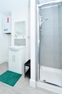 een badkamer met een douche en een wastafel bij Townhouse @ 543 London Road Stoke in Trent Vale