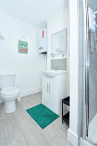 a bathroom with a toilet and a sink and a shower at Townhouse @ 543 London Road Stoke in Trent Vale