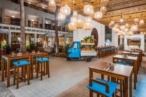 a restaurant with wooden tables and blue chairs at INNSiDE by Meliá Alcudia in Port d'Alcudia