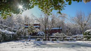 a snow covered yard with a fence and a house at El Rincón de Castilla in Puerto de Béjar