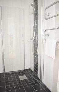 uma casa de banho com um chuveiro e uma porta de vidro em Apartments Lund em Lund
