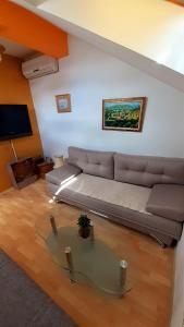 a living room with a couch and a glass table at Studio Dani in Mostar