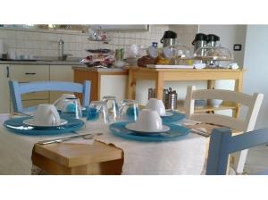 a kitchen with a table with dishes on it at La Caletta Bed and Breakfast in Torre Santa Sabina