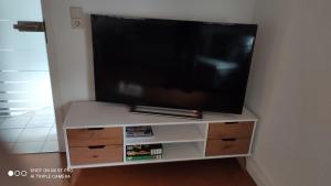 een flatscreen-tv op de top van een wit entertainment center bij Schwarz-Weiss in Rust