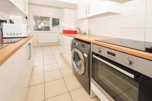 a white kitchen with a washing machine in it at Townhouse @ 178 Ruskin Road Crewe in Crewe