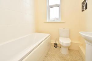 a bathroom with a tub and a toilet and a sink at Townhouse @ 178 Ruskin Road Crewe in Crewe