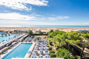 - une vue sur la piscine avec parasols et la plage dans l'établissement Hotel Palace, à Bibione