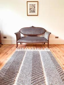 un sofá sentado en una habitación con una alfombra en Oakshaw Apartment, en Paisley