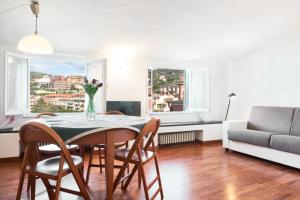 een woonkamer met een tafel en stoelen en een bank bij Square views in Lerici