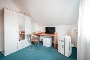 Zimmer mit einem Schreibtisch, einem Computer und einem Stuhl in der Unterkunft Airport Lounge Hotel Düsseldorf in Düsseldorf