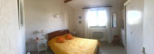 - une chambre avec un lit doté de draps jaunes et d'oreillers orange dans l'établissement Confort et calme à deux pas des plages de Valras, à Valras-Plage