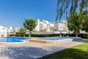 a swimming pool in a yard with buildings in the background at Espanatour AZAHAR DEL MAR in Torrevieja