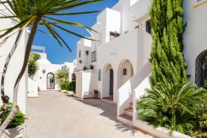a street with white buildings and palm trees at Espanatour AZAHAR DEL MAR in Torrevieja