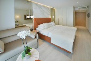 a bedroom with a large bed and a couch at Mediteran Hotel & Resort in Budva