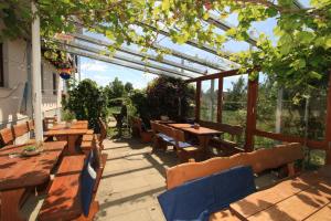 eine Terrasse mit Holztischen und -stühlen und einer Pergola in der Unterkunft Hotel-Pension- Vesperstube Waldblick in Mainhardt