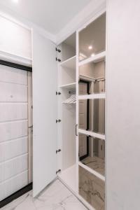 a white walk in closet with a glass door at Royal Tower VIP Smart Apartments 3 in Kyiv